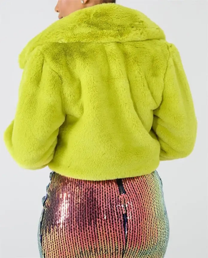 Person wearing a bright green fluffy jacket with a sequined multicolor skirt.
