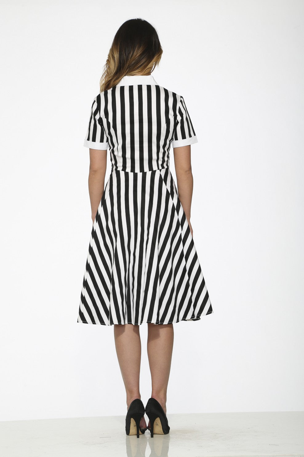 Back view of a black and white striped swing dress showcasing its elegant design.