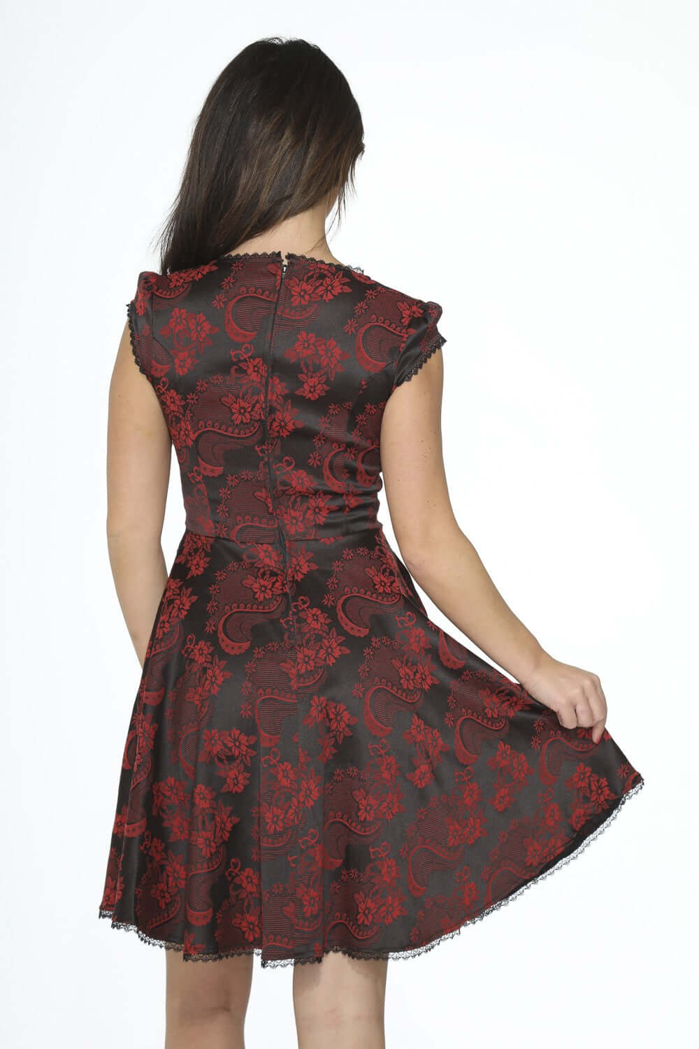 Back view of a model wearing a black red brocade swing dress with pockets featuring a floral pattern.