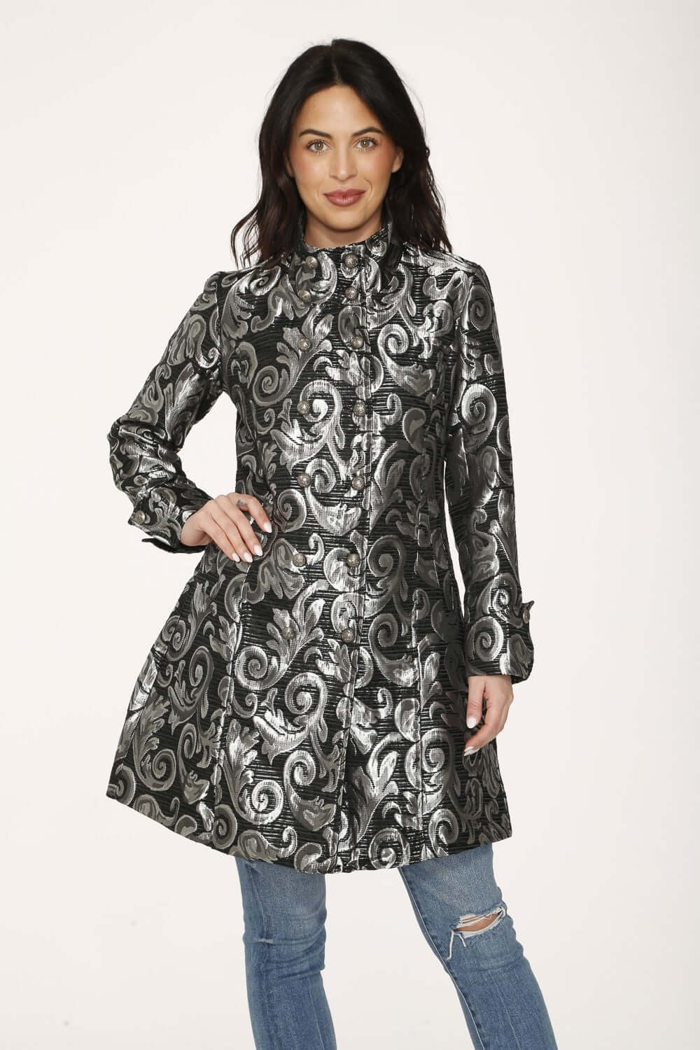 Model wearing a silver brocade women's coat with a high collar and double-button front, showcasing a shiny metallic design.
