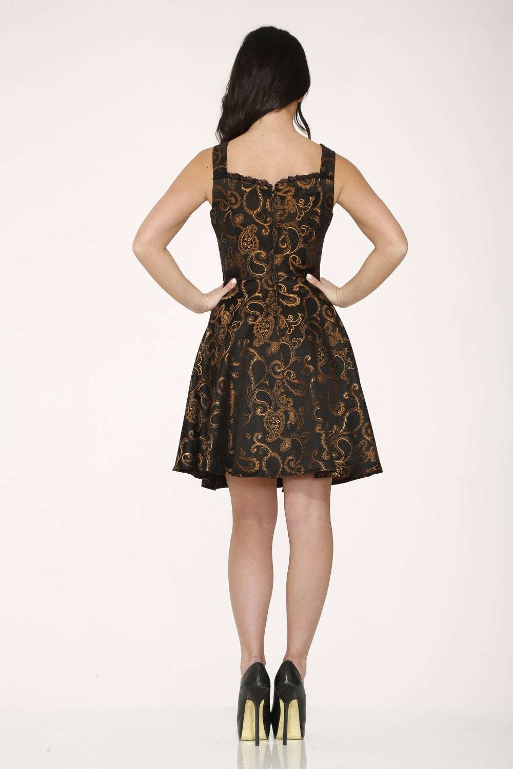 Woman wearing a black dress with gold patterns on a white background