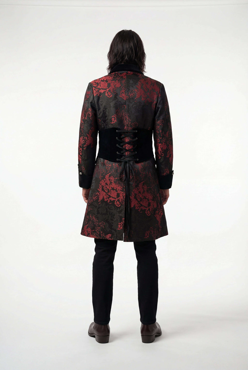 Person wearing a black coat with red floral patterns on a white background