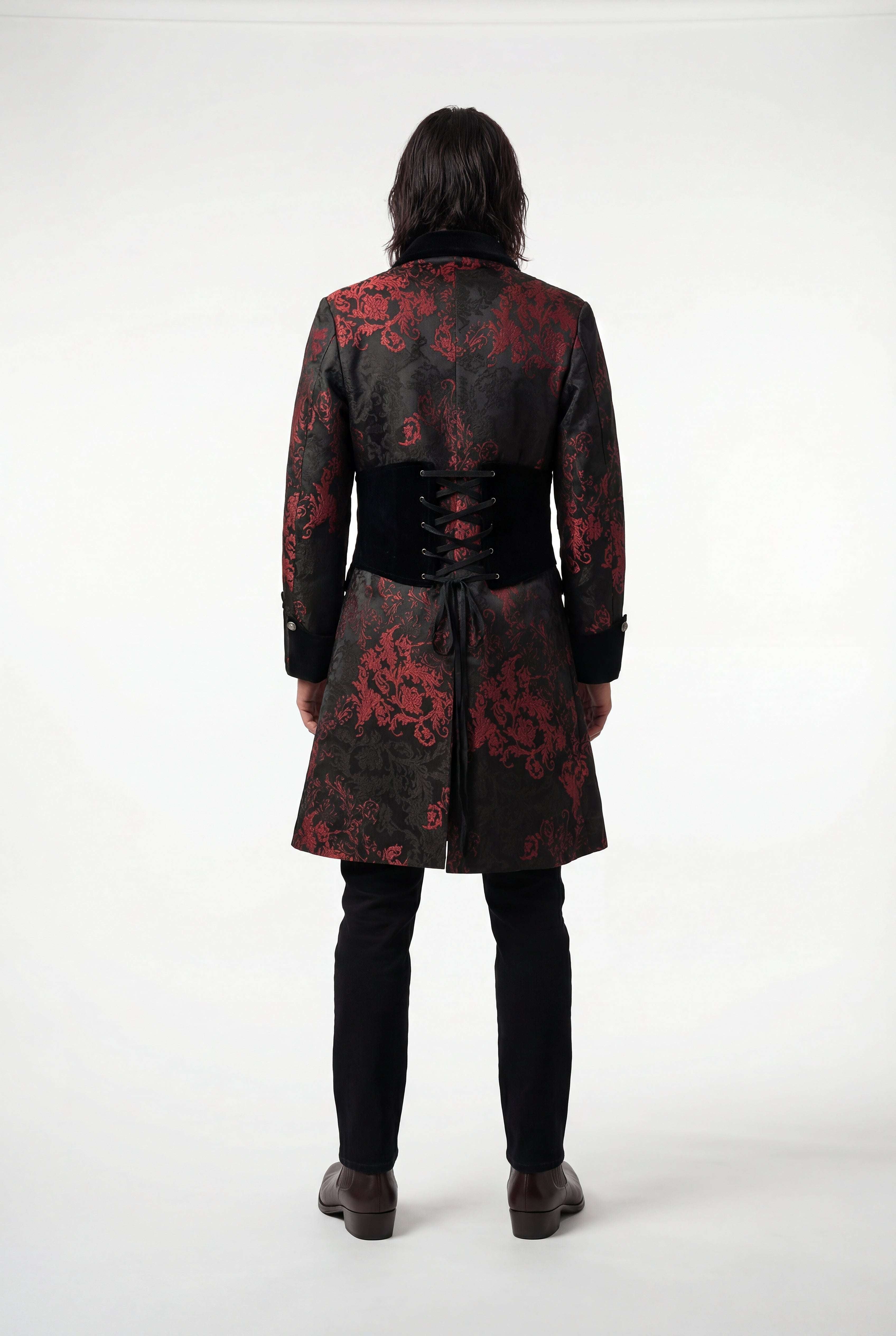 Person wearing a black coat with red floral patterns on a white background