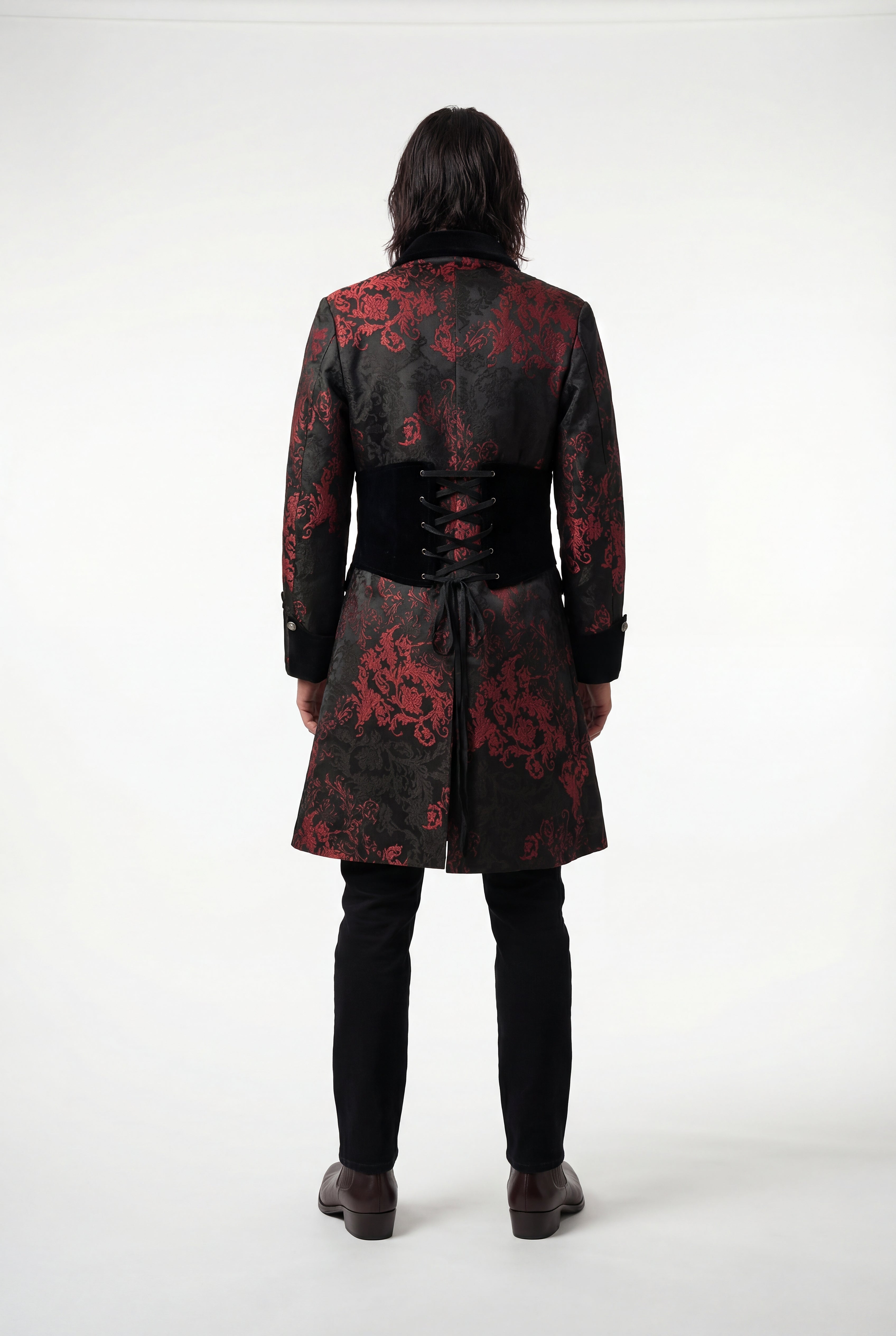 Person wearing a black coat with red floral patterns on a white background