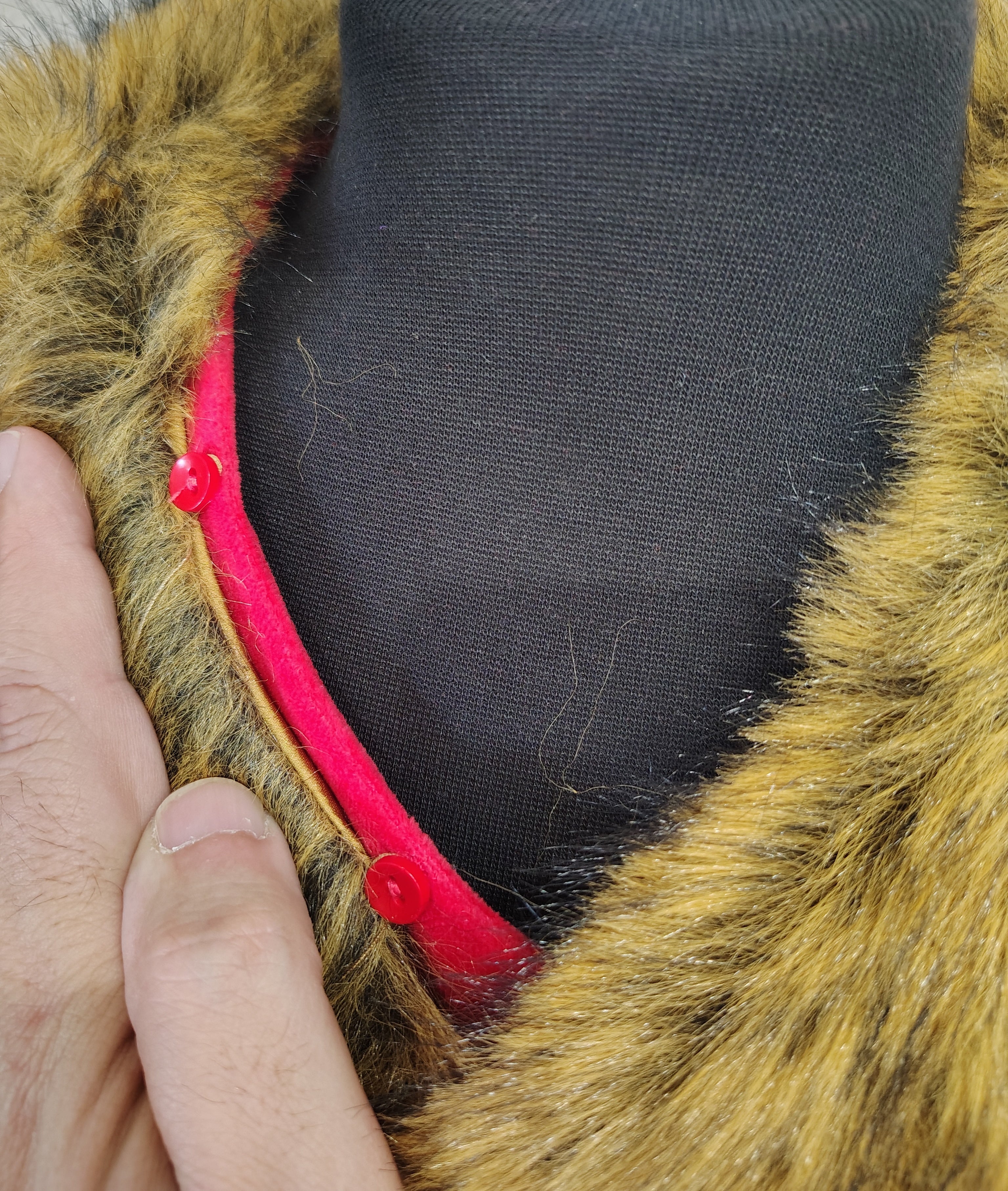 Close-up of the collar detail on the Trim & Tradition Santa Suit, featuring a faux fur trim and red buttons.