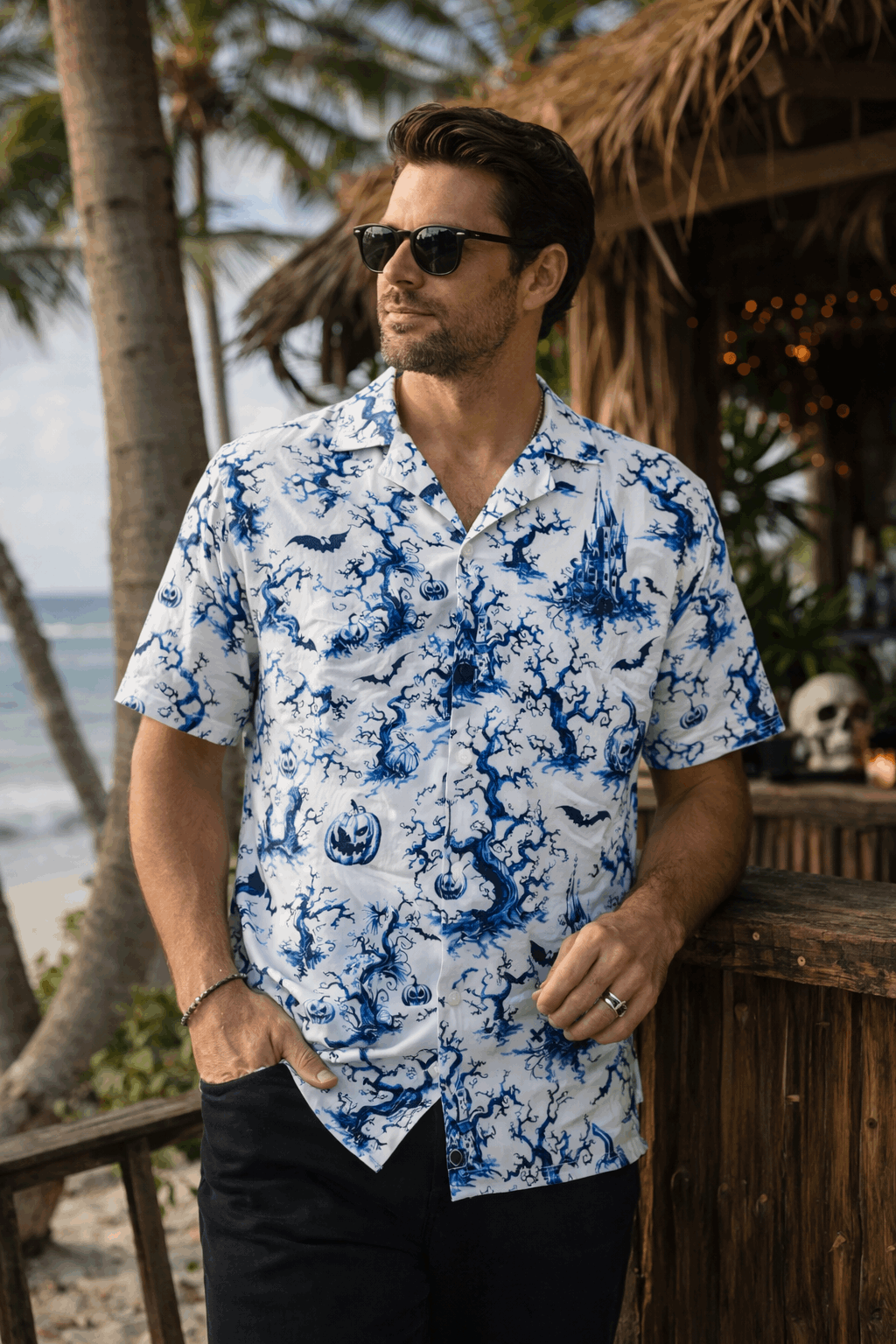 Man wearing a Chinois-eerie gothic button-up shirt with blue-on-white haunted motifs, standing outdoors.