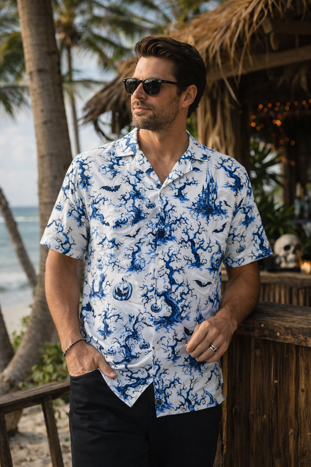 Man wearing a Chinois-eerie gothic button-up shirt with blue-on-white haunted motifs, standing outdoors.