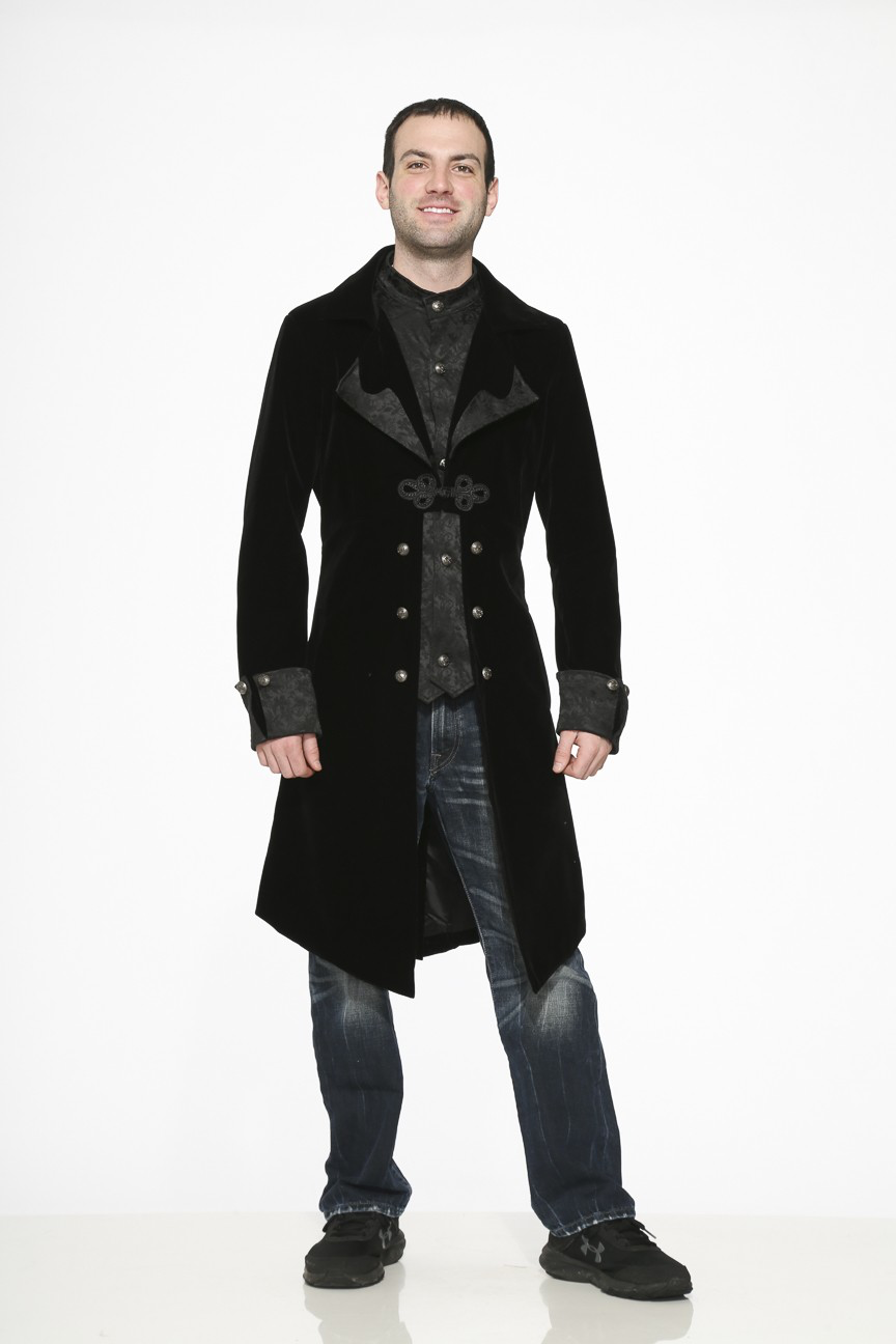 Victorian inspired velvet coat worn by a man, featuring a braided frog closure and a stylish inset vest.