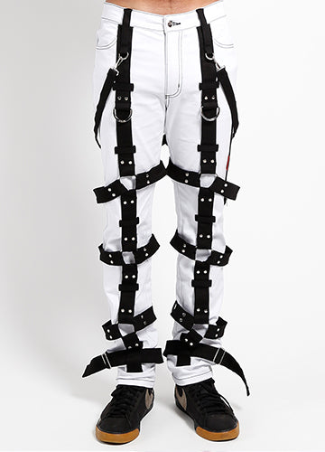White bondage pants with harness featuring black straps and D-rings, styled for a bold fashion statement.