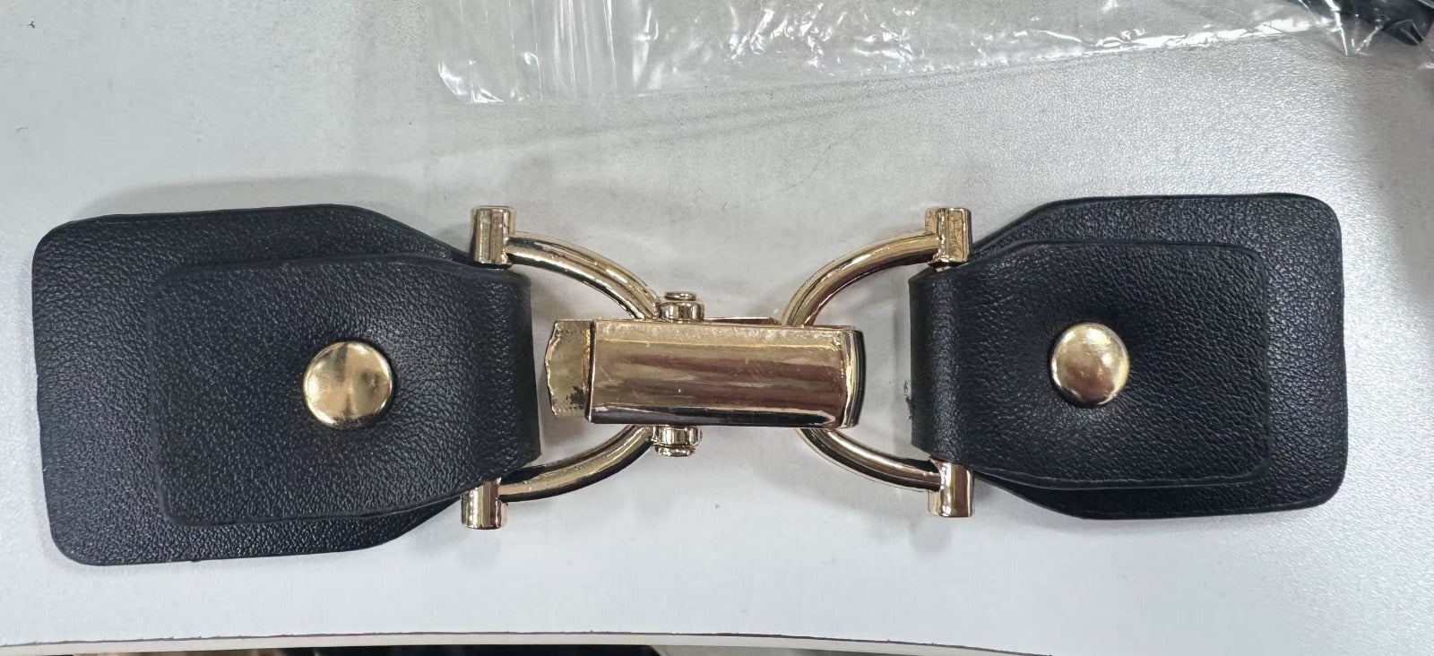 Close-up view of a black and gold toggle hardware clasp for precision fastening.
