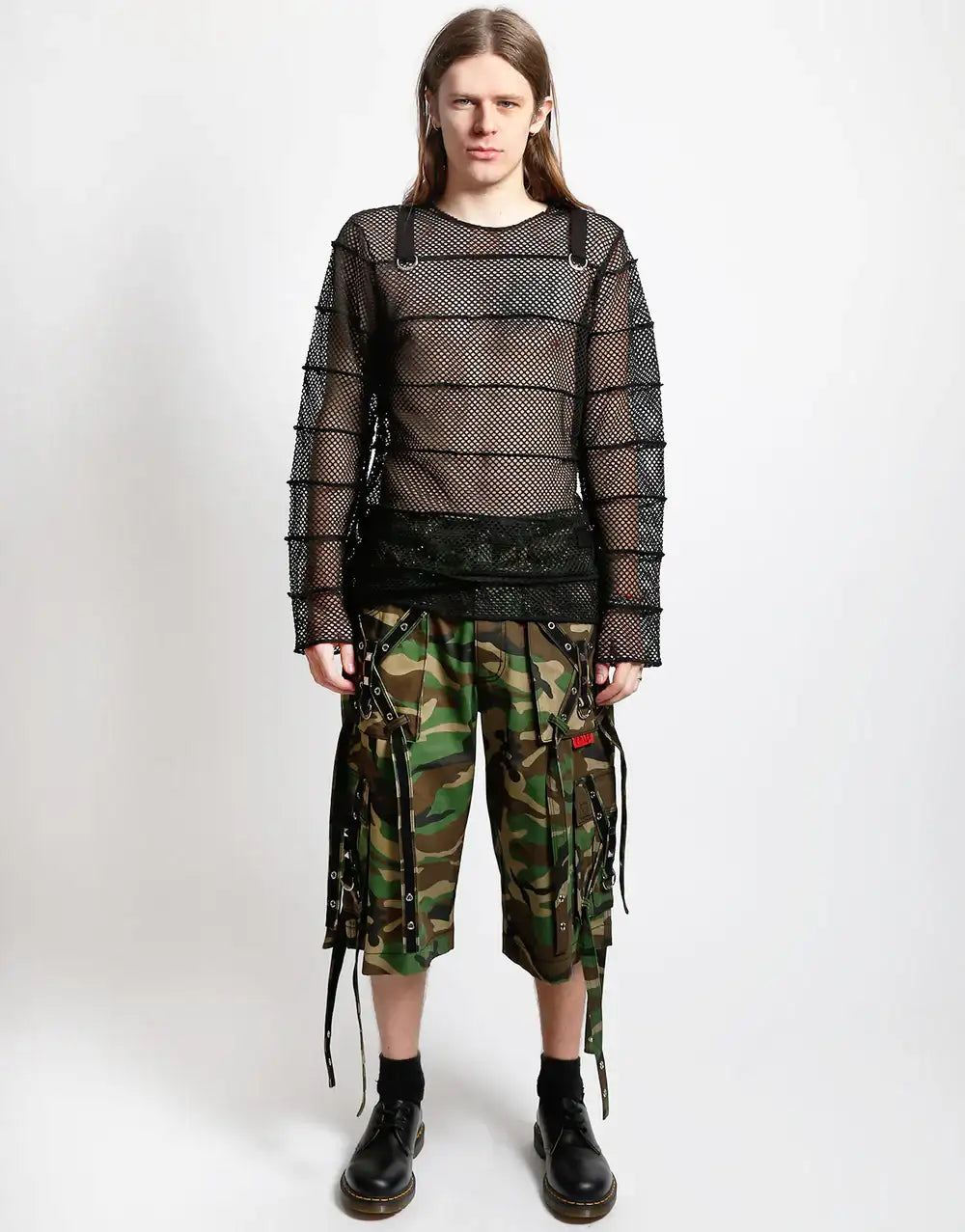 Model wearing a Tripp NYC striped mesh jersey top with D-ring detail and camo cargo shorts.