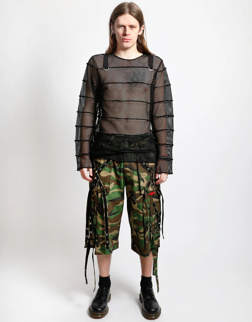 Model wearing a Tripp NYC striped mesh jersey top with D-ring detail and camo cargo shorts.