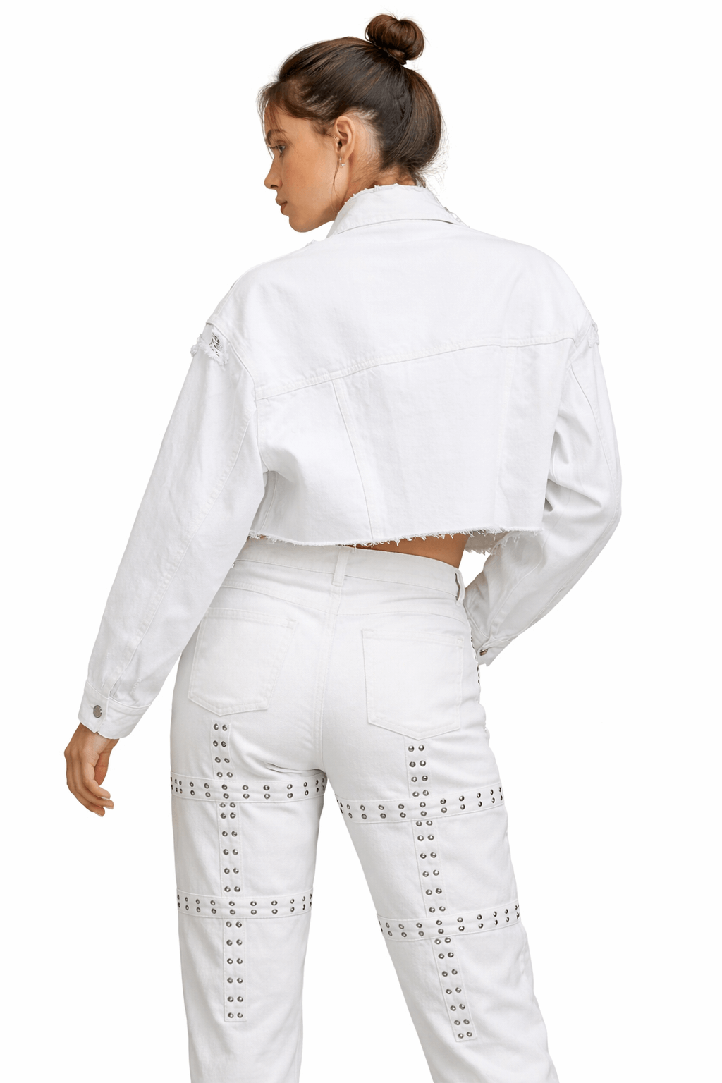 Back view of a woman wearing an Asylum white cropped distress jeans jacket, showcasing its oversized fit and raw-edge hem.