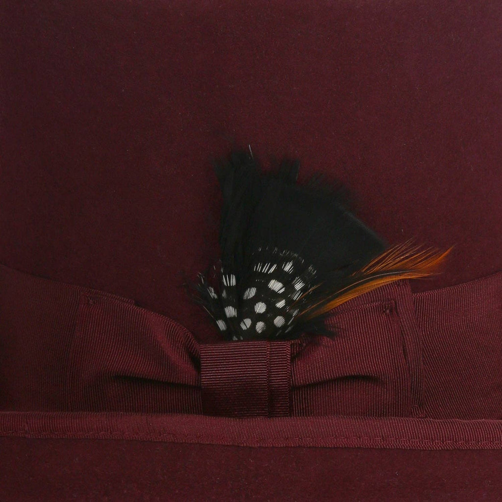  wool top hat in burgundy with grosgrain ribbon and feather accent.