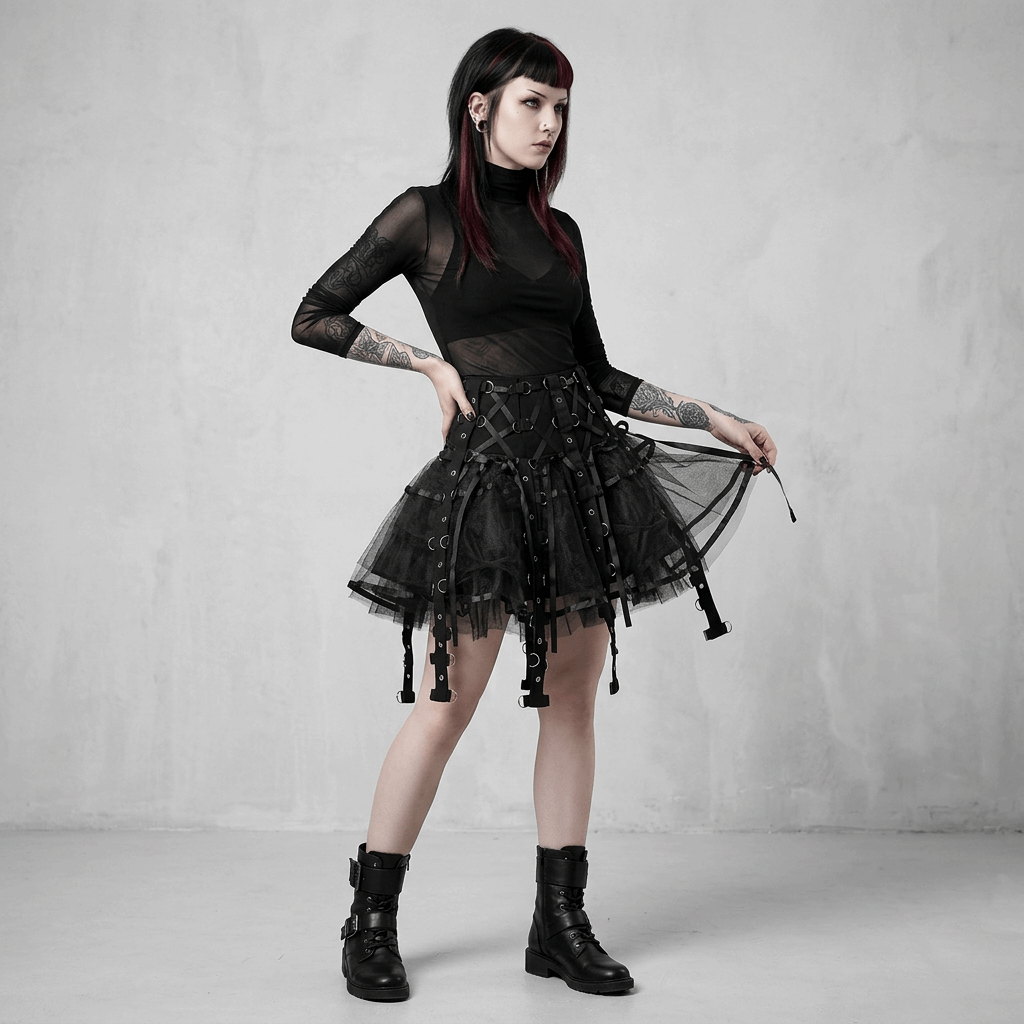 Person wearing a black gothic outfit with a tulle skirt against a gray background